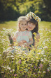 © TwinkleStudio - Happy beautiful mother lady posing with her cute little daughter in lovely scene of family summer life on meadow of daisy poppy flowers together