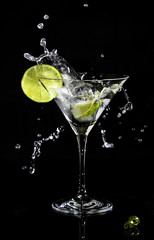 Martini splash in a cocktail glass with a slice of lime on a side