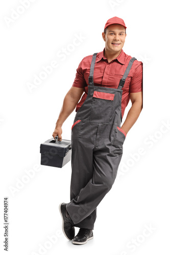 Fotografía Repairman holding a toolbox and leaning against a wall