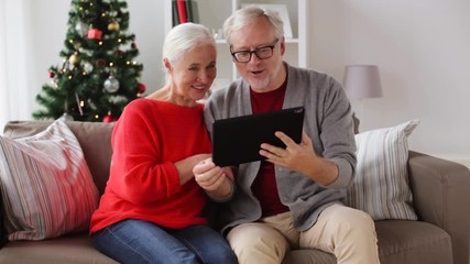 Poster - happy senior couple with tablet pc at christmas