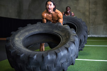 Male Fit Athlete Pushes Himself To Lift Heavy Weight Tire In A Race For Cross Training