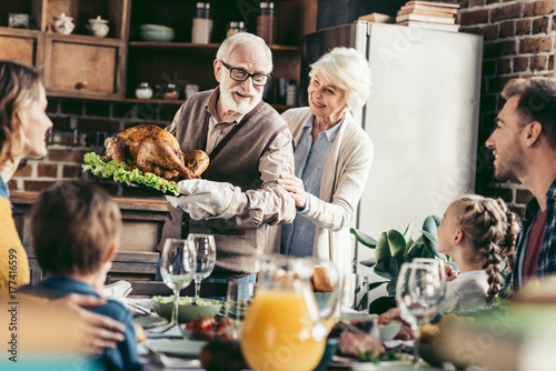 Fotografie, Obraz grandpa with delicious turkey for thanksgiving