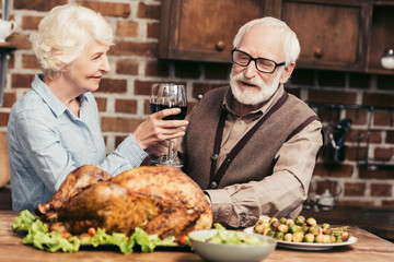 Wall Mural - senior couple drinking wine on thanksgiving