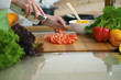 © rogerphoto - Closeup of human hands cooking vegetables salad in kitchen on the glass  table with reflection