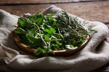 Fresh herbs in wooden plate