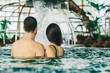 © victortorres/Stocksy - Rear view of couple relaxing in a spa center