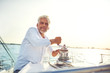 © Flamingo Images - Mature man using winch on his boat while out sailing