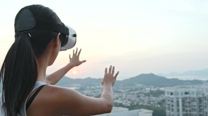 Wall Mural - Woman looking though virtual reality device at outdoor