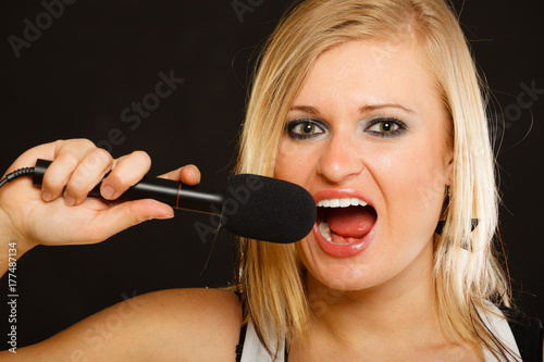 Plakat Blond kobieta śpiewa do mikrofonu