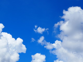 Clear bright blue sky with big white clouds, with grey shadow background, with big chunks coming from both left and right