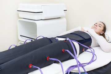 Woman at the clinic for the treatment of pressure therapy procedure 