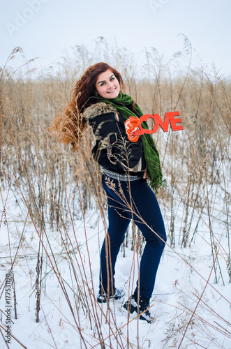 A Young Girl Walks In The Field Dressed In Winter Clothes She