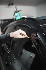 Wall Mural - Car tinting - Worker applying tinting foil on car window. 