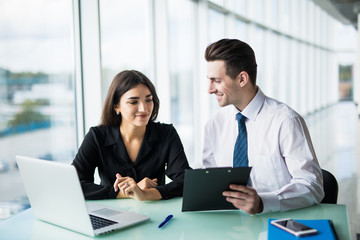 Client signing a document in an office with a businesswoman looking the contract. Office work