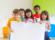 © weedezign - Diversity children holding blank poster in classroom at kindergarten preschool,Multiethnic Group with sign board,mock up for adding text or design