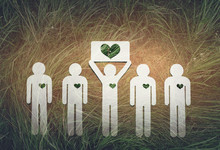 Paper People On Green Grass On Bright Background. Greenpeace, A Symbol Of The Heart From The Grass. Protection And Love Of Nature And Ecology.
