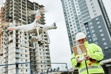 Wall Mural - drone operated by construction worker on building site