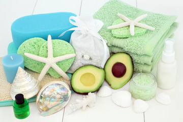 Wall Mural - Skincare and spa beauty treatment with avocado, bath salts, sponges, face cloths, aromatherapy essential oil, body lotion, bath foam and decorative shells on white wood background.