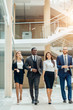 © alfa27 - cheerful young business people talking while walking outdoors