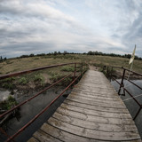 Fototapeta Dziecięca - Walk along the wooden bridge in the village from one bank of the river to the other.