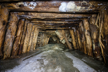 Old abandoned underground mica ore mine shaft tunnel with ice frost