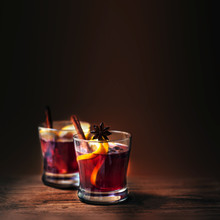 Hot Mulled Wine For Winter And Christmas  On Wooden Background With Copyspace.  Red Hot Wine With Orange Fruit And Spices