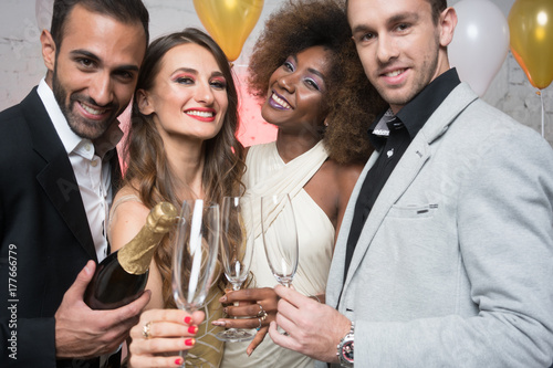 Zdjęcie XXL Człowiek na nowy rok lub przyjęcie urodzinowe otwiera butelkę z winem musującym wraz ze swoimi przyjaciółmi