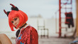 © Artem Markin - Halloween. Portrait of a beautiful girl in a red wig with horns closeup. Red, festive makeup.