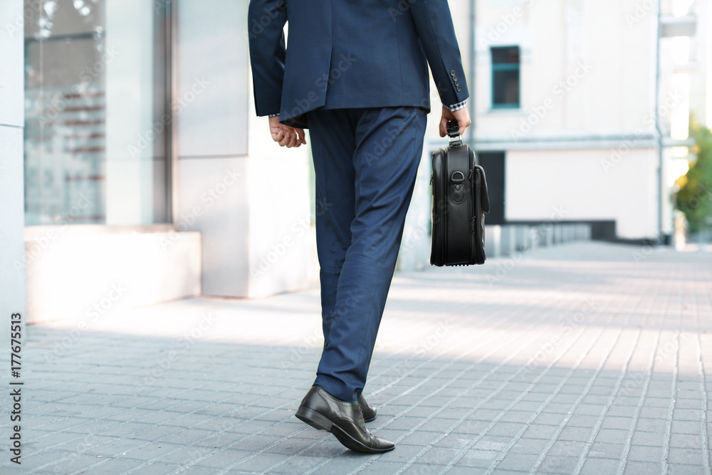 Handsome successful businessman in elegant suit outdoors