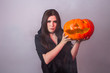 © satura_ - Halloween witch holding a orange pumpkin Jack o Lantern with smoke