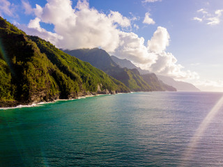 Amazing aerial view of the Na Pali coast cliffs from above. Beautiful Pacific ocean, sunlight and green cliffs of the Hawaii islands. 