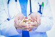 © lenets_tan - Doctor holding heap of drugs in a hand. Woman doctor