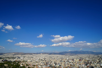 Wall Mural - view of athens cityscape showing lowrise white buildings, mountain, trees, white cloud and bright bl