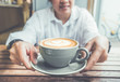 © weedezign - Close up asian woman holding hot cappuccino coffee cup in cafe,food and drink lifestyle,focus on cup