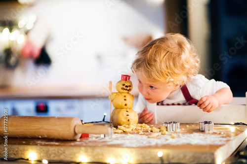 Fotografie, Obraz Toddler boy making gingerbread cookies at home.