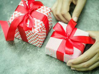 Wall Mural - Female hand holding a gift box with red ribbon.  Love, valentine, christmas and new year concept.