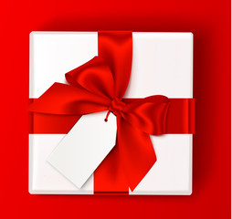 Wall Mural - realistic white gift box with red bow and empty sale tag isolated on red background. holiday decorat