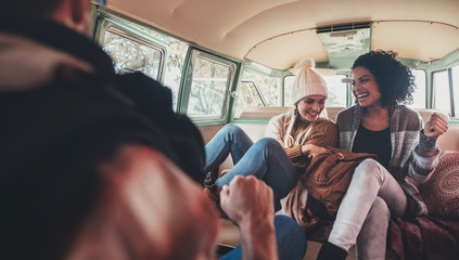 Friends on road trip having fun inside van