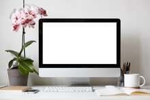 Picture Of Modern Personal Computer With Blank White Copy Space Screen Resting On Desk With Keyboard, Orchid In Pot, Mug, Cellular Phone, Copybooks And Stationery Items. Mock Up Of Workplace