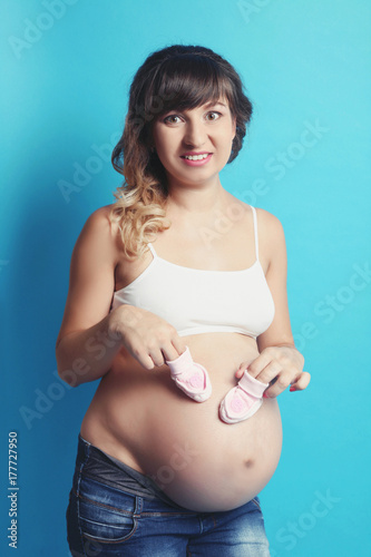 Zdjęcie XXL kobieta w ciąży z bucikami dla niemowląt