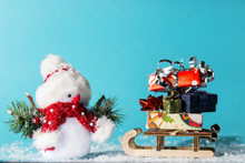 Snowman And Sledge With Christmas Gifts On Cyan Background