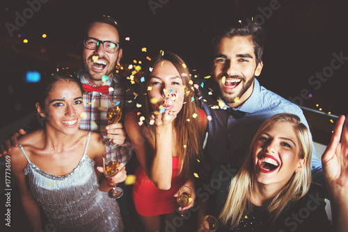 Fotografía Group of people having a party, blowing confetti