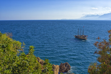 Wall Mural - Panoramic view on Mediterranean sea and a sailing ship. Antalya, Turkey