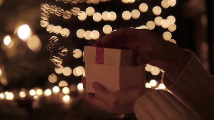 Wall Mural - woman open the gift box with golden light magic on bokeh lights background.