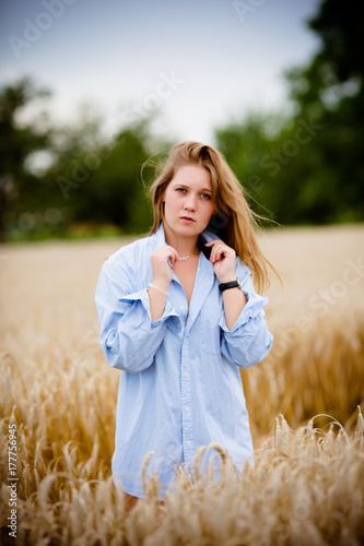 Plakat smutna młoda kobieta w polu pszenicy