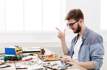 Poster - Engineer checking broken computer motherboard