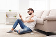 © Prostock-studio - Young man at home with mobile feel pain