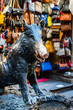 Bronze sculpture of a wild boar in Florence, Italy, with leather goods market stall in the background.