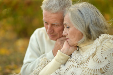 Sad senior couple in  park