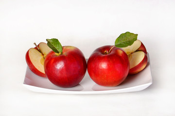 Two apples and sliced apples on the plate.